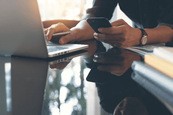 Personne utilisant un téléphone portable et un ordinateur portable